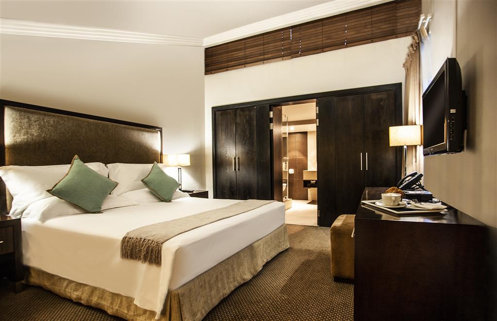 Interior view of bedroom in Avani Superior Room with king bed and bathroom view