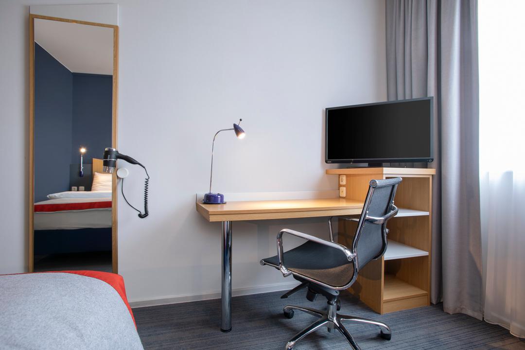 Warmly decorated room with a work desk and a smart TV.