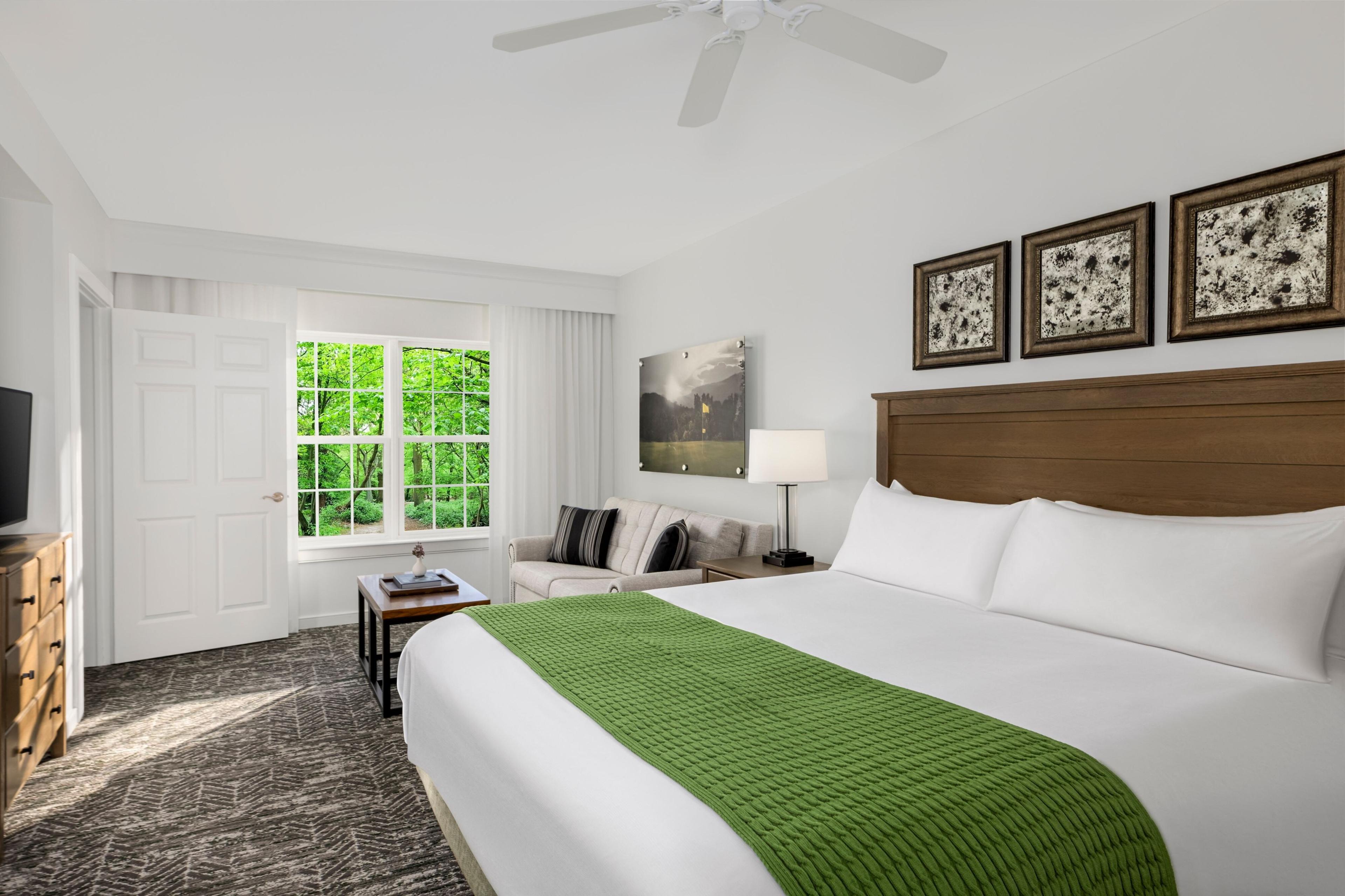 The villa second bedroom is spacious and designed for modern comfort, including a king bed with plush linens and a comfortable seating area with a pull-out couch, perfect for groups visiting Atlantic City.