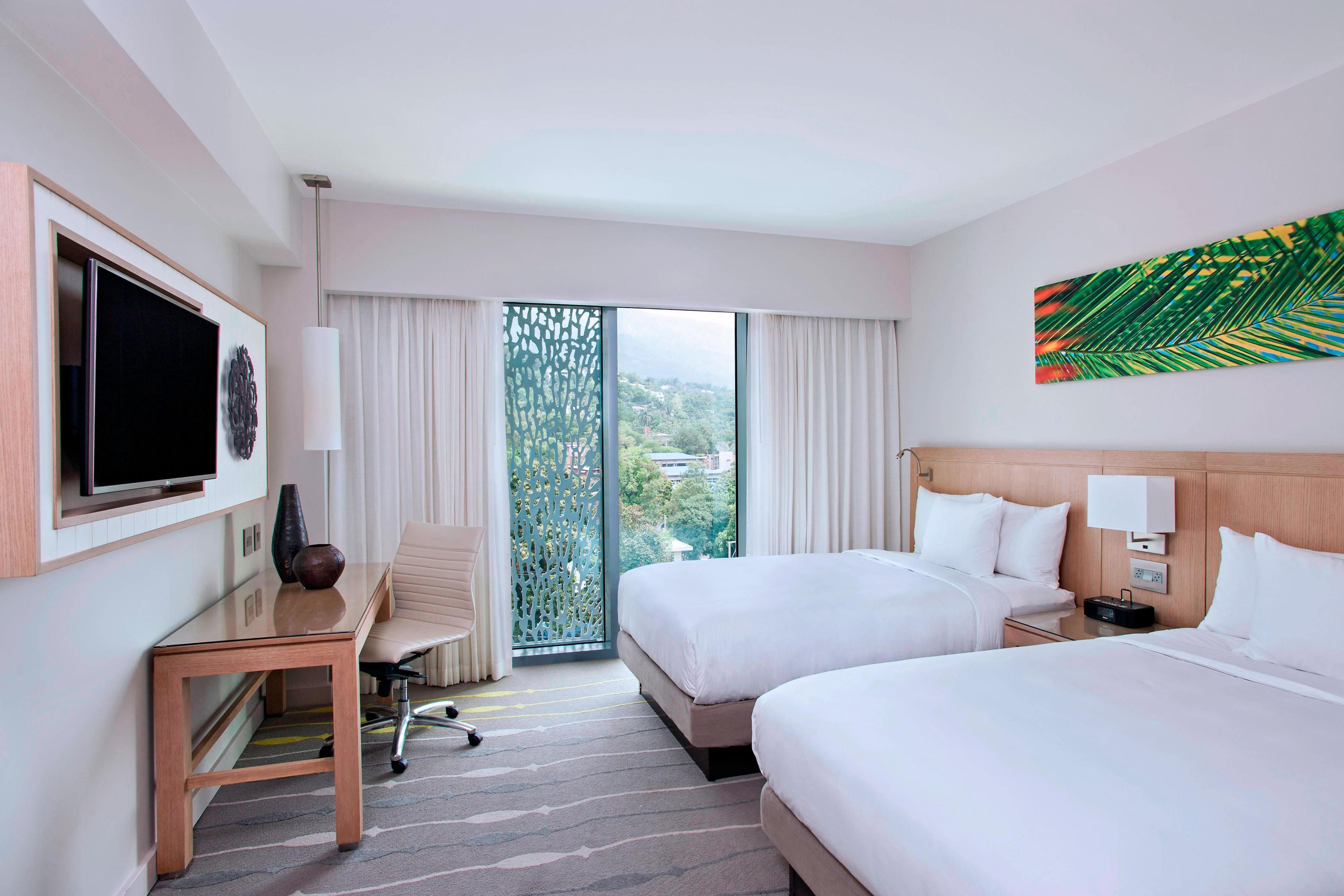 Inspired by the local beauty of Port Au Prince, our double/double guest rooms offer unique artwork, chic furnishings and floor-to-ceiling windows.