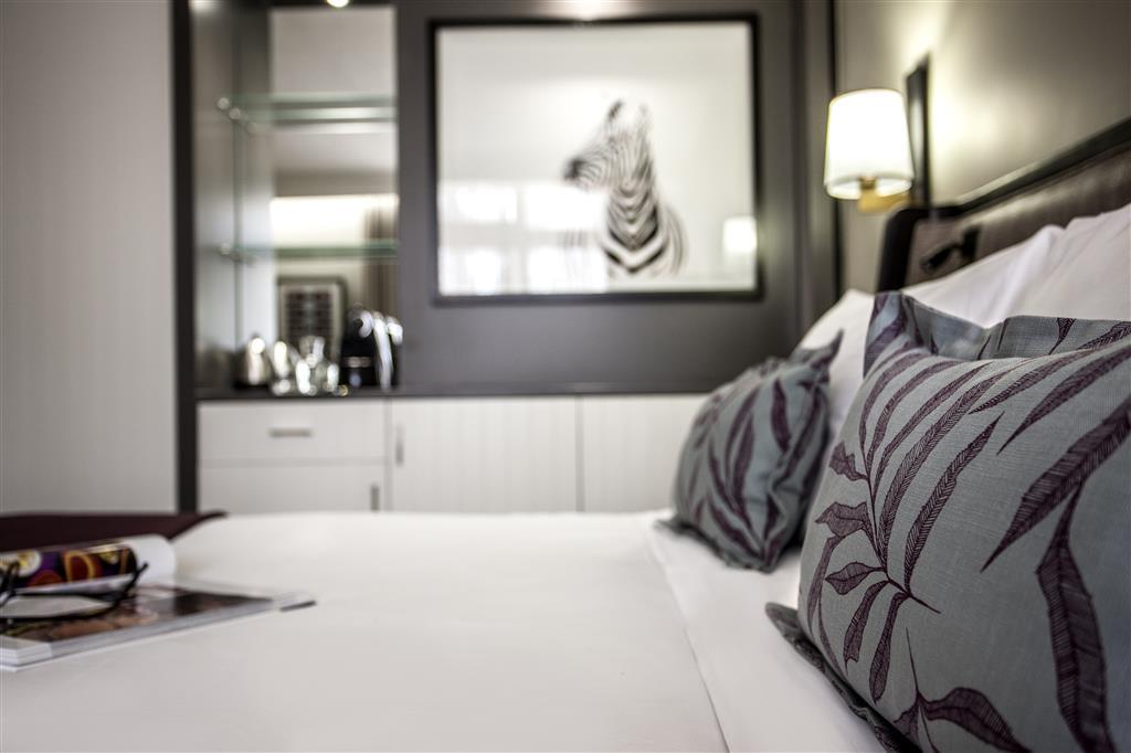 The Avani room pillows with a picture of a zebra on the wall.