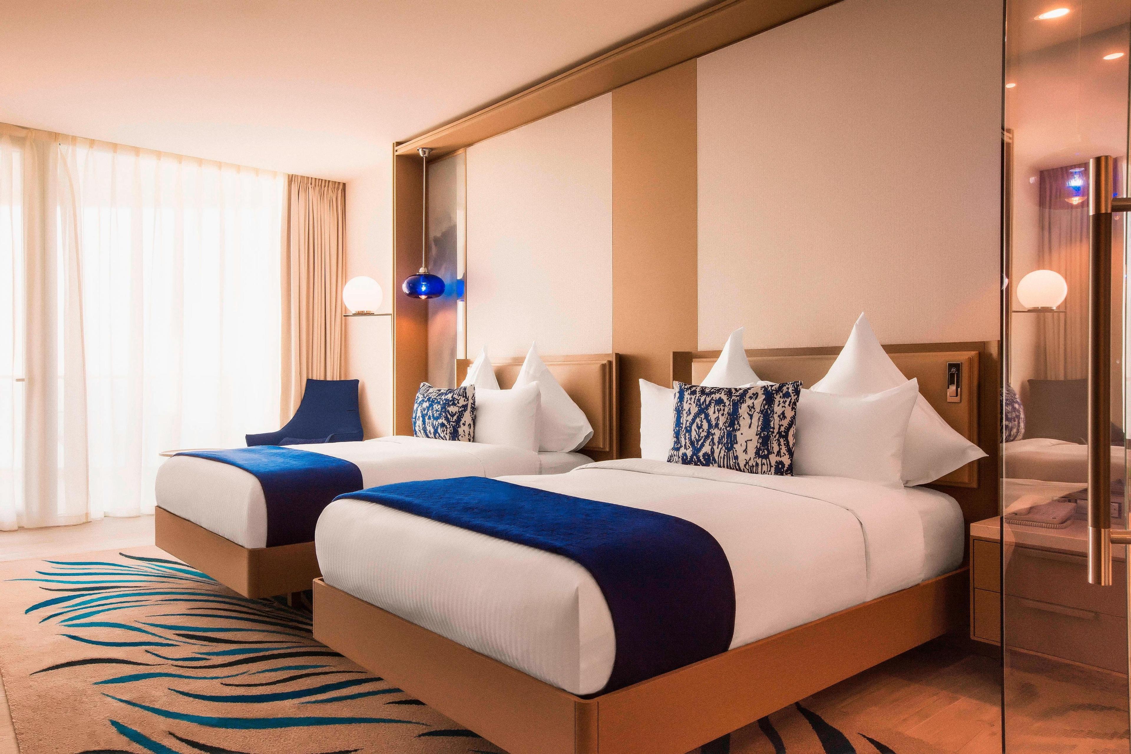 Our Deluxe Double room includes two soft queen size double beds, a comfortable living area and a private balcony. The bathroom is equipped with both a bathtub and power shower, encased in a pristine glass screen.