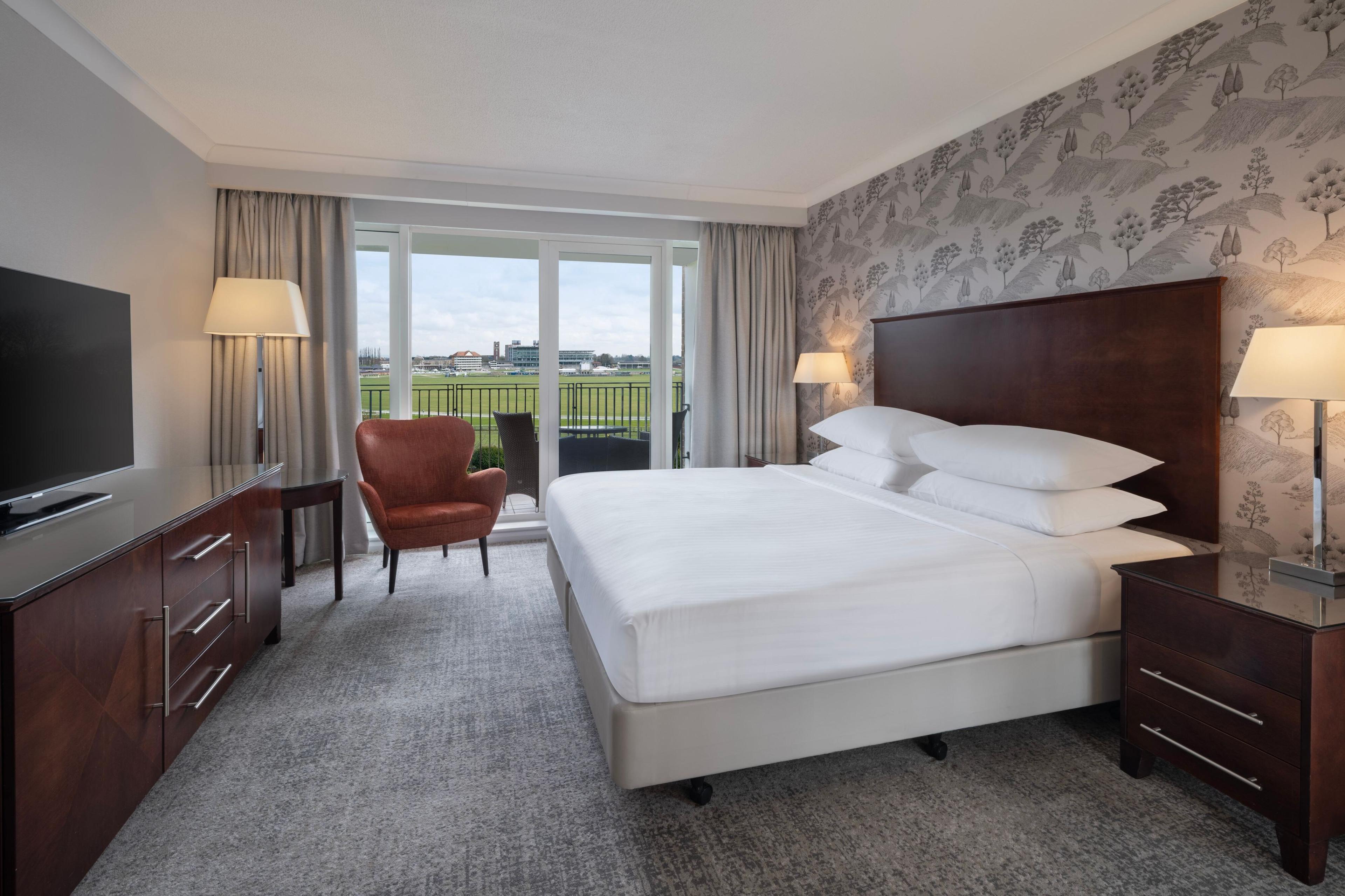 Spacious Grandstand guest bedroom with views of York Racecourse from a patio or balcony, kingsize bed and sitting area with, flatscreen TV, free WiFi and complimentary parking.