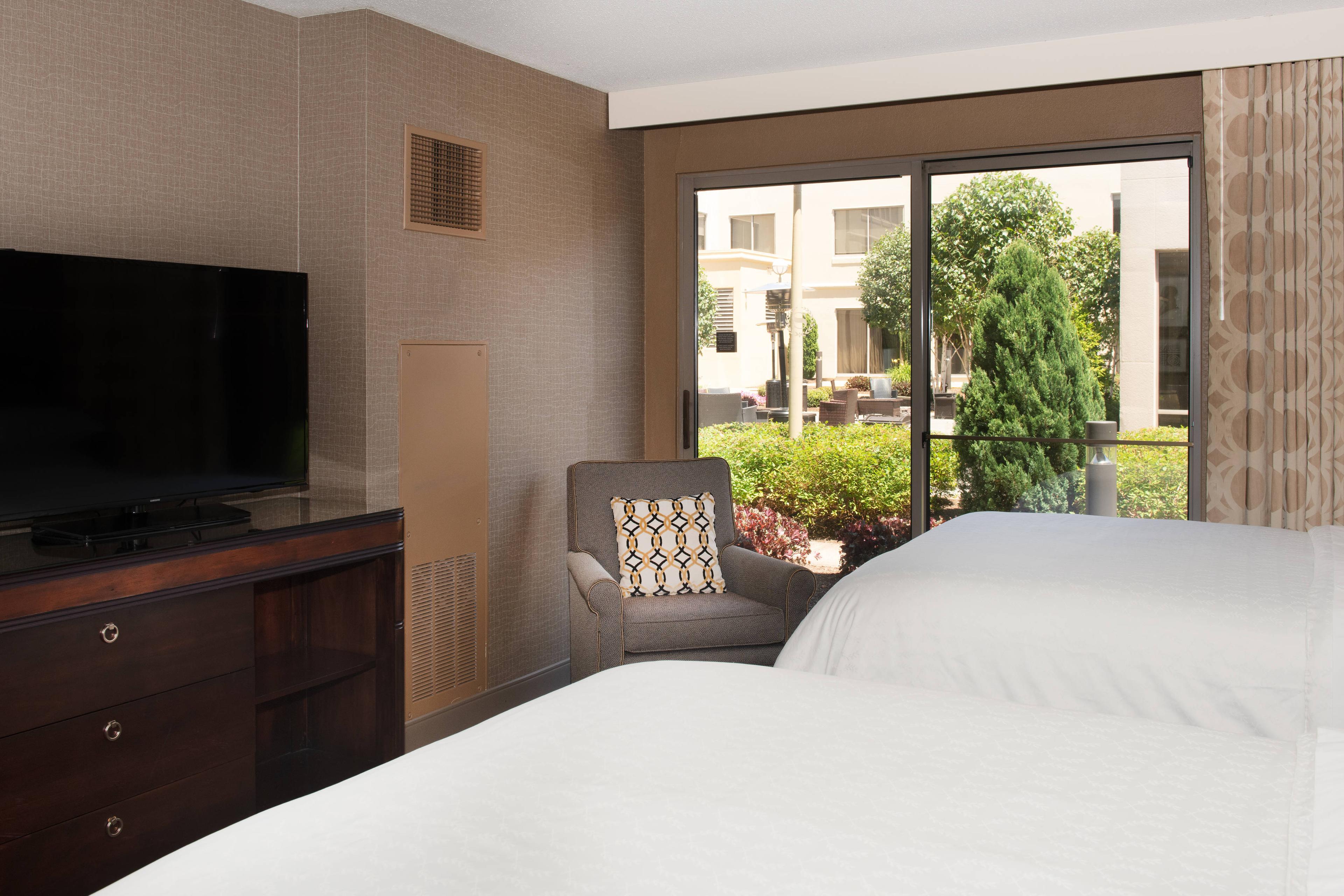 Deluxe Double Bed with sliding glass door access to the courtyard.