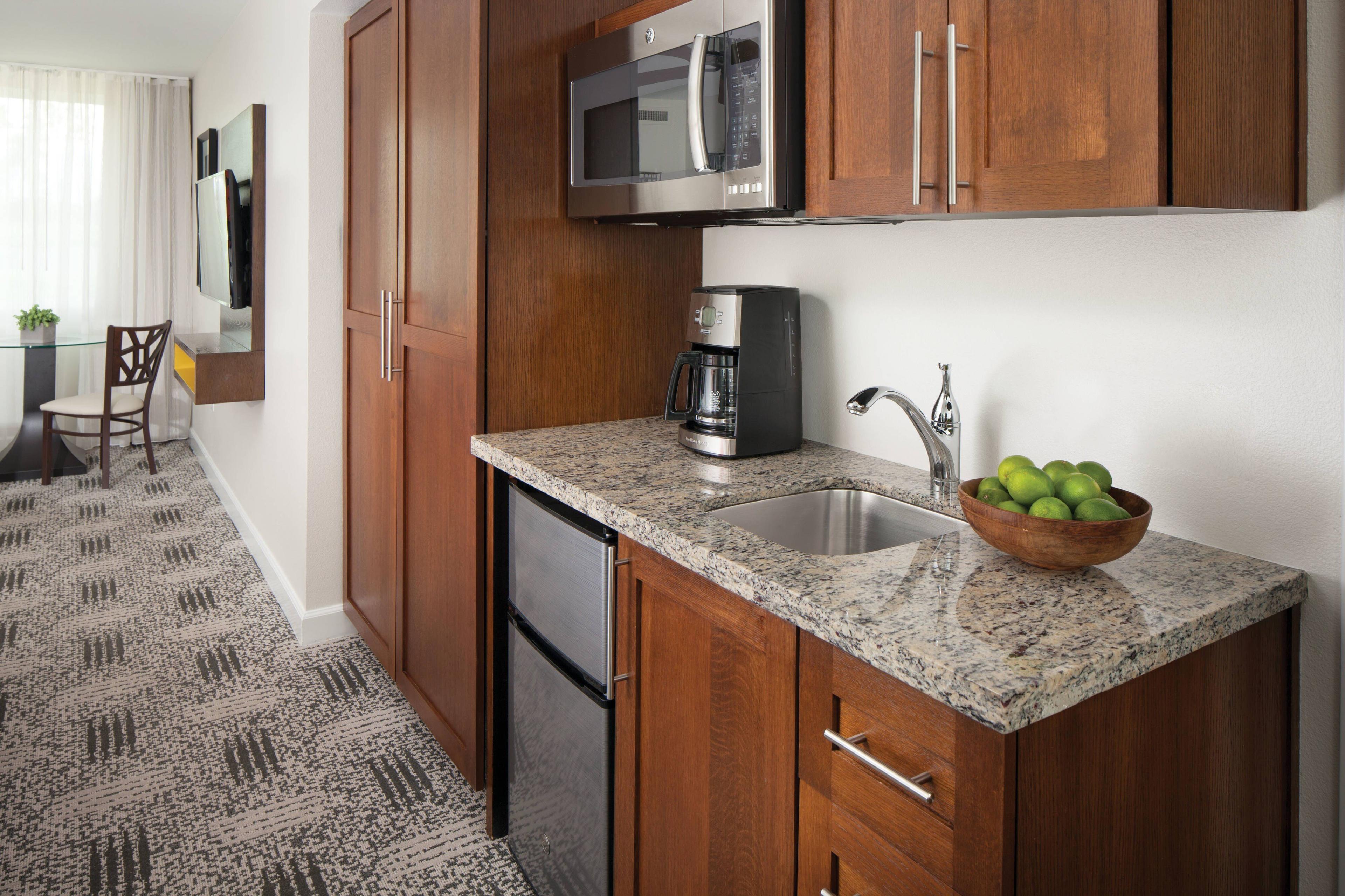 The comfortable guest room features a kitchenette with a mini-refrigerator, a microwave, a coffee maker and dishes.